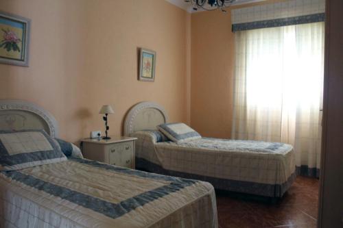 a bedroom with two beds and a window at Casa juan in Algodonales