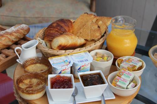 une table avec un panier de pain et d'autres aliments dans l'établissement Chambre d'Hôtes aux Sables d'Olonne, à Les Sables-dʼOlonne
