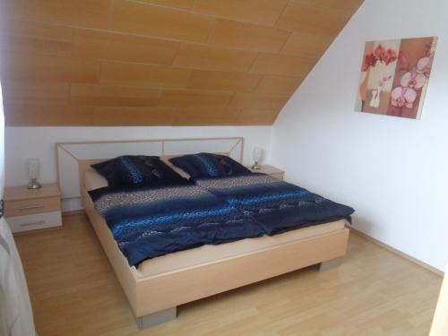 1 dormitorio con 1 cama con mantas y almohadas azules en Ferienwohnung Kapust, en Hessisch Oldendorf