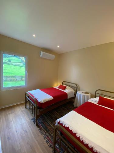 a room with two beds and a window at Lake Cottage - Panoramic views 7 Cidades in Sete Cidades