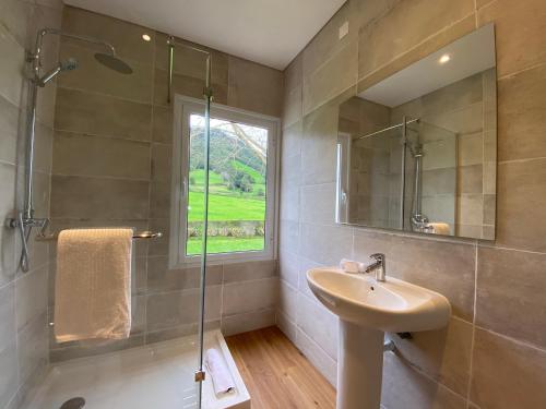 uma casa de banho com um lavatório e uma cabina de duche em vidro. em Lake Cottage - Panoramic views 7 Cidades em Sete Cidades