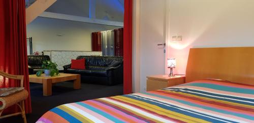 sypialnia z łóżkiem, krzesłem i kanapą w obiekcie Apartment Campinor w mieście Neerpelt