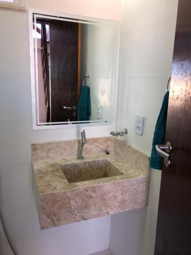 a bathroom with a sink and a mirror at TRANQUILA FLATS in Morro de São Paulo