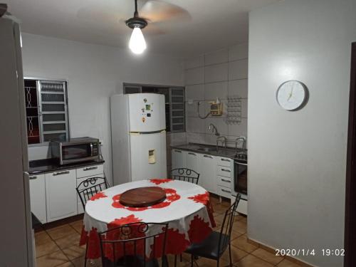 uma cozinha com uma mesa e um frigorífico branco em DOURADOS GUEST FLAT HOUSE em Dourados