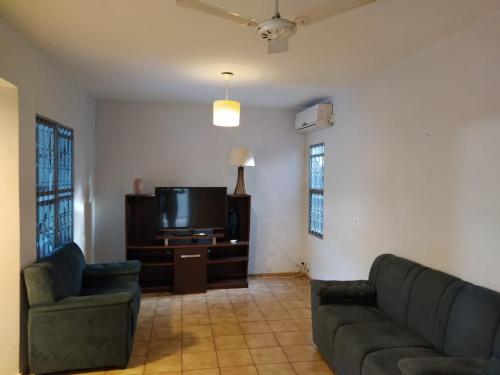 a living room with two couches and a flat screen tv at DOURADOS GUEST FLAT HOUSE in Dourados