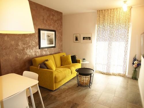 a living room with a yellow couch and a table at Apartments House Filipović in Makarska