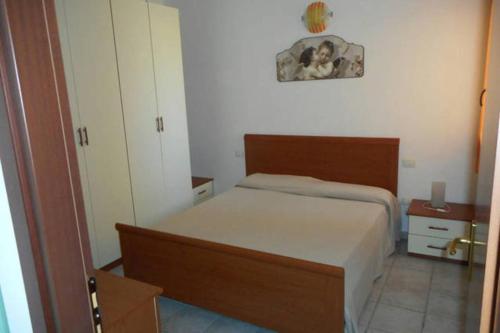 a small bedroom with a bed and a clock on the wall at Appartamento 72 in Torre Dei Corsari