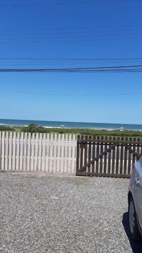 a fence and a car parked in front of a fence at Meu pequeno paraíso in Itapoa