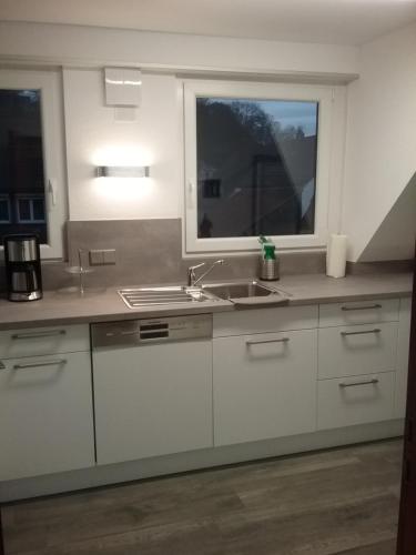 a kitchen with white cabinets and a sink and a window at Pension Wauri , Ferienwohnung ' SCHÖNBUCH ' , zweites Obergeschoss in Waldenbuch