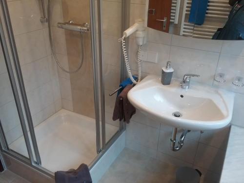a bathroom with a sink and a shower at Ferienwohnung "SCHÖNBUCH" , Pension Wauri in Waldenbuch