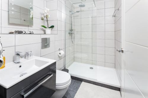 y baño con aseo, lavabo y ducha. en Centrally located apartment in Duke Street- free parking- two bathrooms en Liverpool