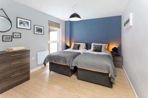 um quarto com uma cama e uma parede azul em Centrally located apartment in Duke Street- free parking- two bathrooms em Liverpool