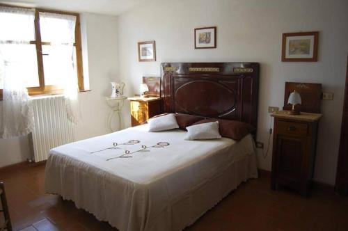 a bedroom with a large bed with a wooden headboard at Villa Il Cerro in Radicofani