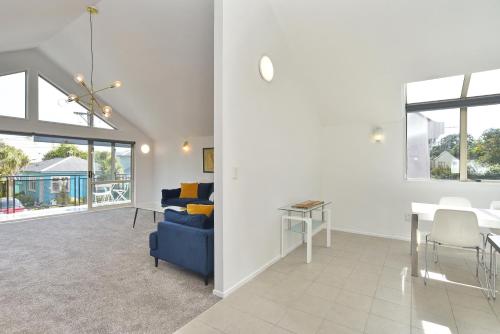 a living room with a blue couch and a table at City Haven - 4BR for Families & Friends, Secure Parking in Christchurch