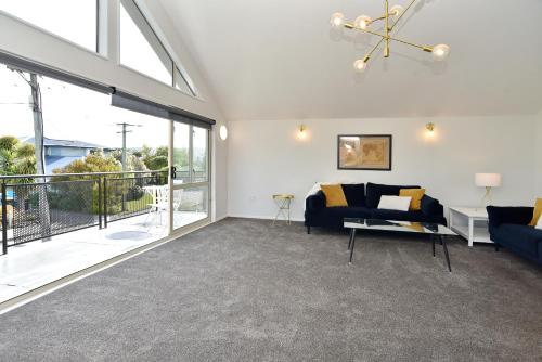 a living room with a couch and a large window at City Haven - 4BR for Families & Friends, Secure Parking in Christchurch