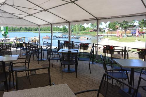 un ristorante con tavoli e sedie con vista sull'acqua di Letnisko Zalesie a Rentyny