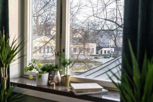 a window with plants and books on a window sill at Botanika Uppsala in Uppsala