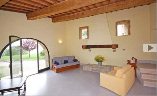 un soggiorno con divano e tavolo di Villa Case Belle a Sarteano