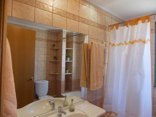 a bathroom with a sink and a toilet and a mirror at Theofilos house in Nafplio