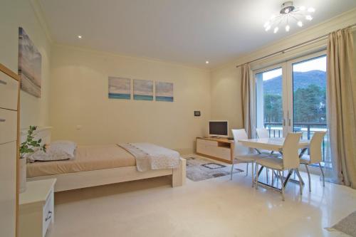 a bedroom with a bed and a desk and a table at Porto Montenegro Zeta 102 - Cozy Studio in Tivat