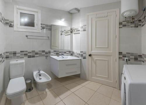 a white bathroom with a toilet and a sink at terrazza e vista oceano, Wi-Fi, aria condizionata, 6º piano in Morro del Jable