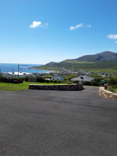 einen Blick auf eine Straße mit dem Meer im Hintergrund in der Unterkunft Achill West Coast House in Dooagh