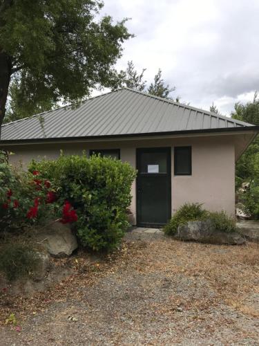 a small white house with a black door at Star Dream Manor in Lake Tekapo