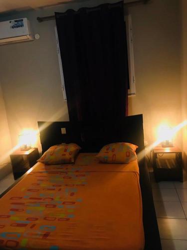 a bedroom with a large bed with two lamps at CHIRIJIEN BLÉ in Le Robert