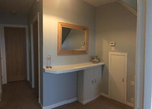 a bathroom with a sink and a mirror on the wall at Tigh Na Mara Holiday Home in Aultbea