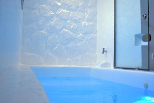 a bathroom with a large mirror and a sink at Aphrodite Luxury Apartments in Agios Prokopios