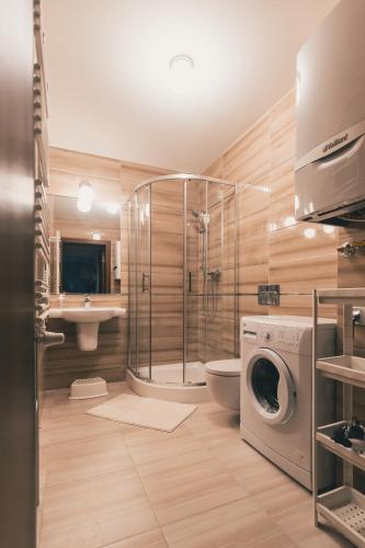 a bathroom with a shower and a washing machine at Sosnowe Tarasy in Mielno