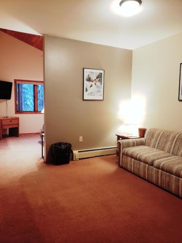 a living room with a couch and a television at North Ironwood Acres - Black River Lodge in Ironwood