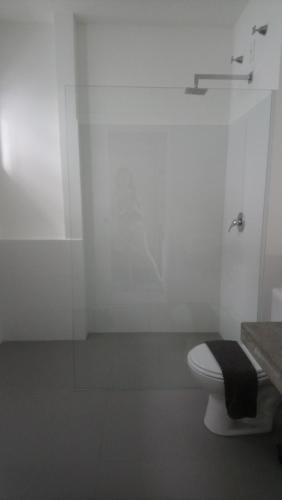 a bathroom with a toilet and a glass shower at KiteBar Hotel in Cumbuco