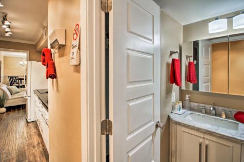 a bathroom with a sink and a white door at Sands Beach Club Condo with Ocean Views and Amenities! in Myrtle Beach