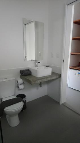 a bathroom with a white toilet and a sink at KiteBar Hotel in Cumbuco