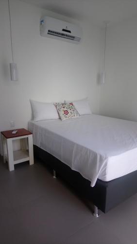a bedroom with a white bed and a table at KiteBar Hotel in Cumbuco