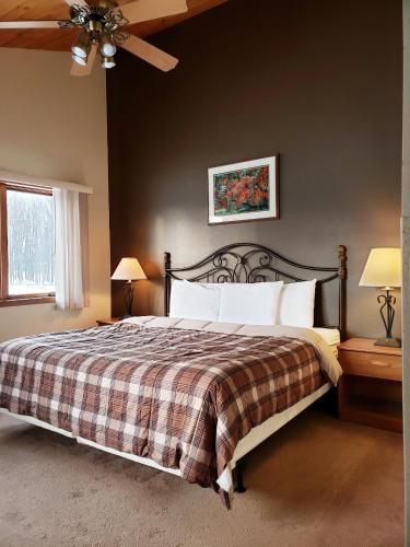 a bedroom with a bed with a checkered blanket at North Ironwood Acres - Black River Lodge in Ironwood