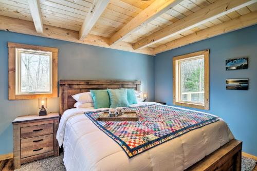 a bedroom with a large bed and two windows at Newly Built Cabin with Hot Tub - 16 Mi to Stowe Mtn! in Morristown