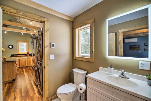 a bathroom with a toilet and a sink and a mirror at Newly Built Cabin with Hot Tub - 16 Mi to Stowe Mtn! in Morristown