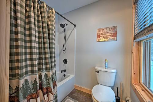 a bathroom with a toilet and a shower curtain at Rustic 3-Story Pittsburg Cabin with Lake and Mtn Views in Pittsburg