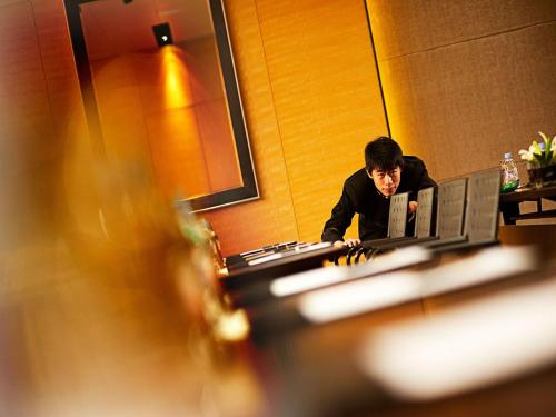 a man sitting at a desk in front of a computer at Enlux Hotel in Jinan