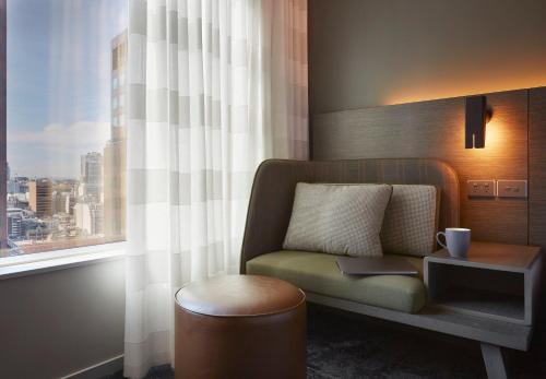 a living room with a chair and a window at Holiday Inn Express Melbourne Southbank by IHG in Melbourne