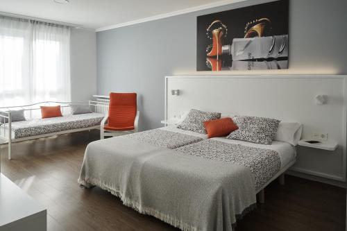 biała sypialnia z łóżkiem i krzesłem w obiekcie Xabarin Rooms w mieście Abadín