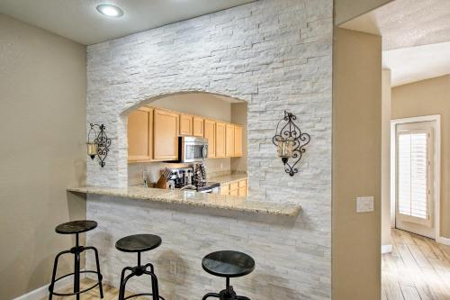 uma cozinha com bancos em frente a uma parede de pedra em Condo with Pool Access about 1 Mi to Old Town Scottsdale em Scottsdale