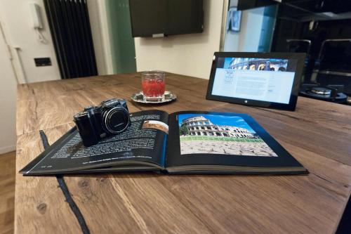 a camera and a book on a table with a laptop at Casa Roma Luxury Apartment in Rome