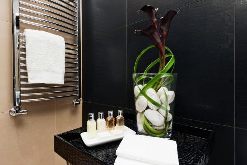 a bathroom with a vase of flowers and a sink at Casa Roma Luxury Apartment in Rome