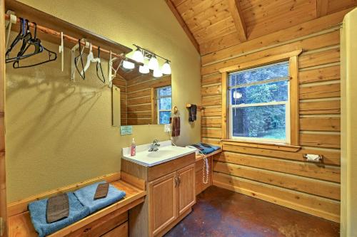 a bathroom with a sink and a mirror at Cozy Cabin on the Creek Near Hiking Trails and Town! in Seward