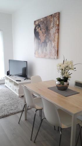 a dining room with a table with chairs and a tv at Lynn's Liverpool Apartment in Liverpool