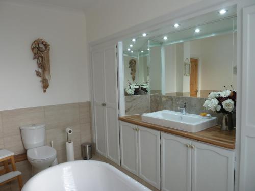 een badkamer met een bad, een wastafel en een toilet bij Beresford81 in Cowes