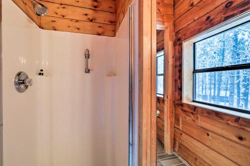 a bathroom with a window and a shower in a house at Furnished Deck Cabin in Coconino National Forest in Munds Park